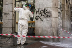 Un operario borra un graffiti en la plazuela de Antonio Vega